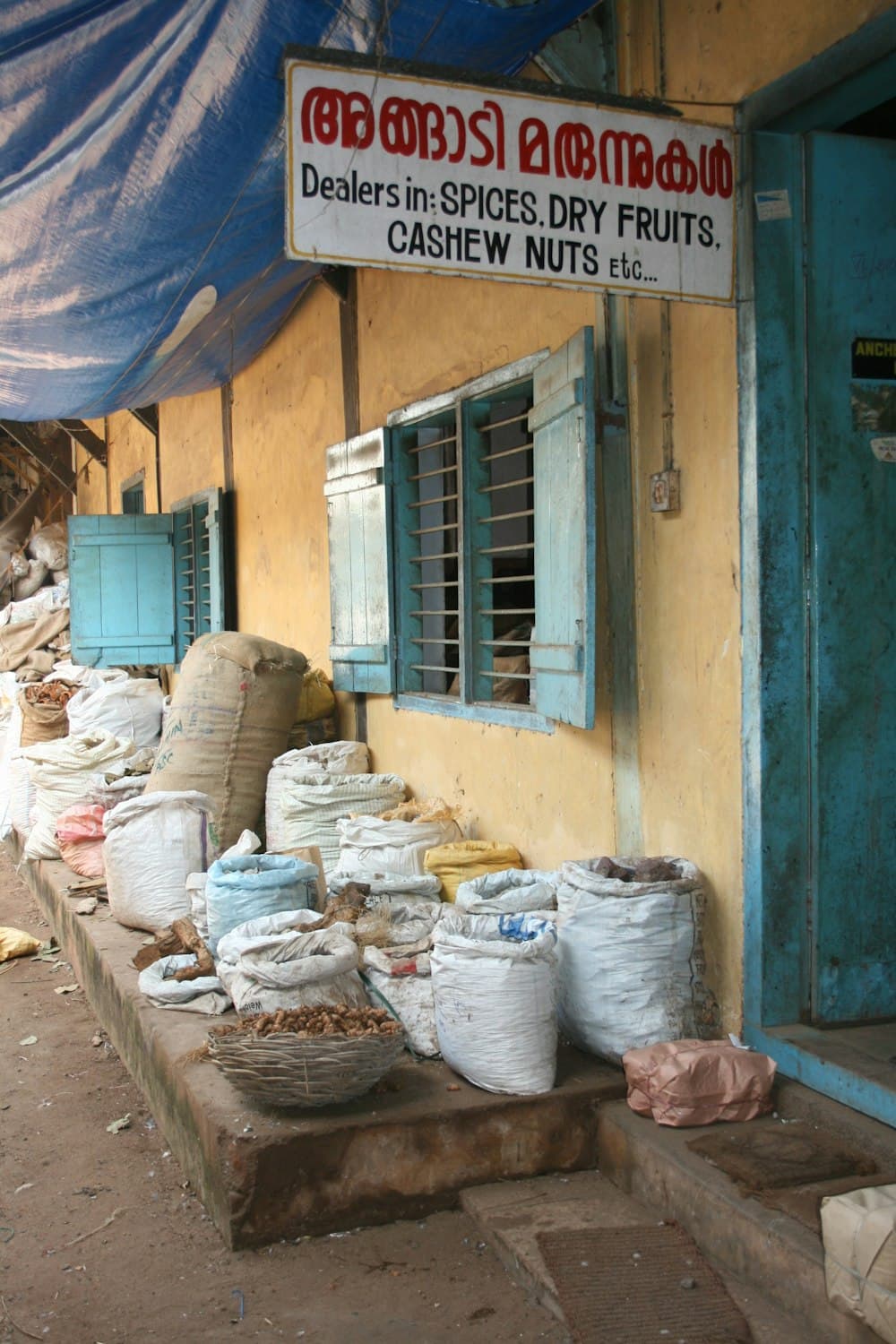 A rustic Indian spice shop with open sacks of turmeric and dried spices
