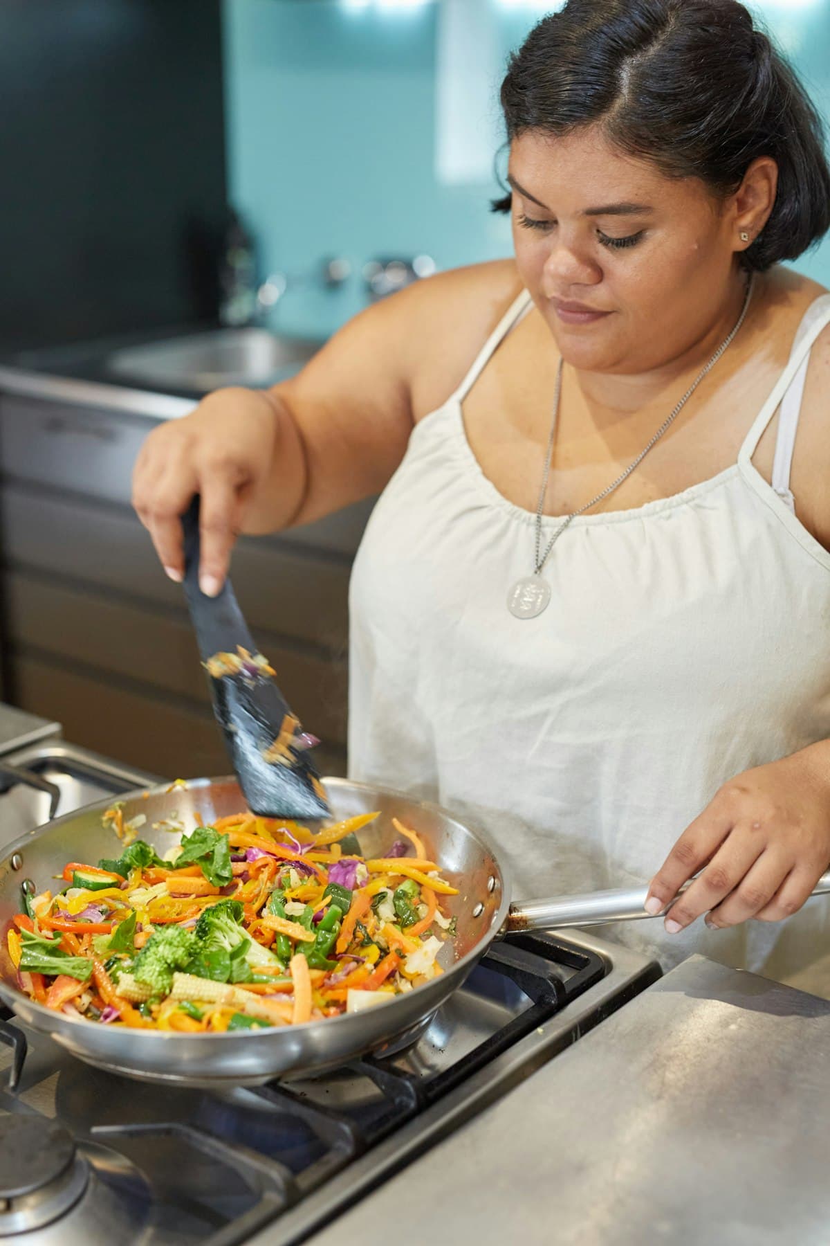 A woman preparing a vegetarian meal in a home kitchen