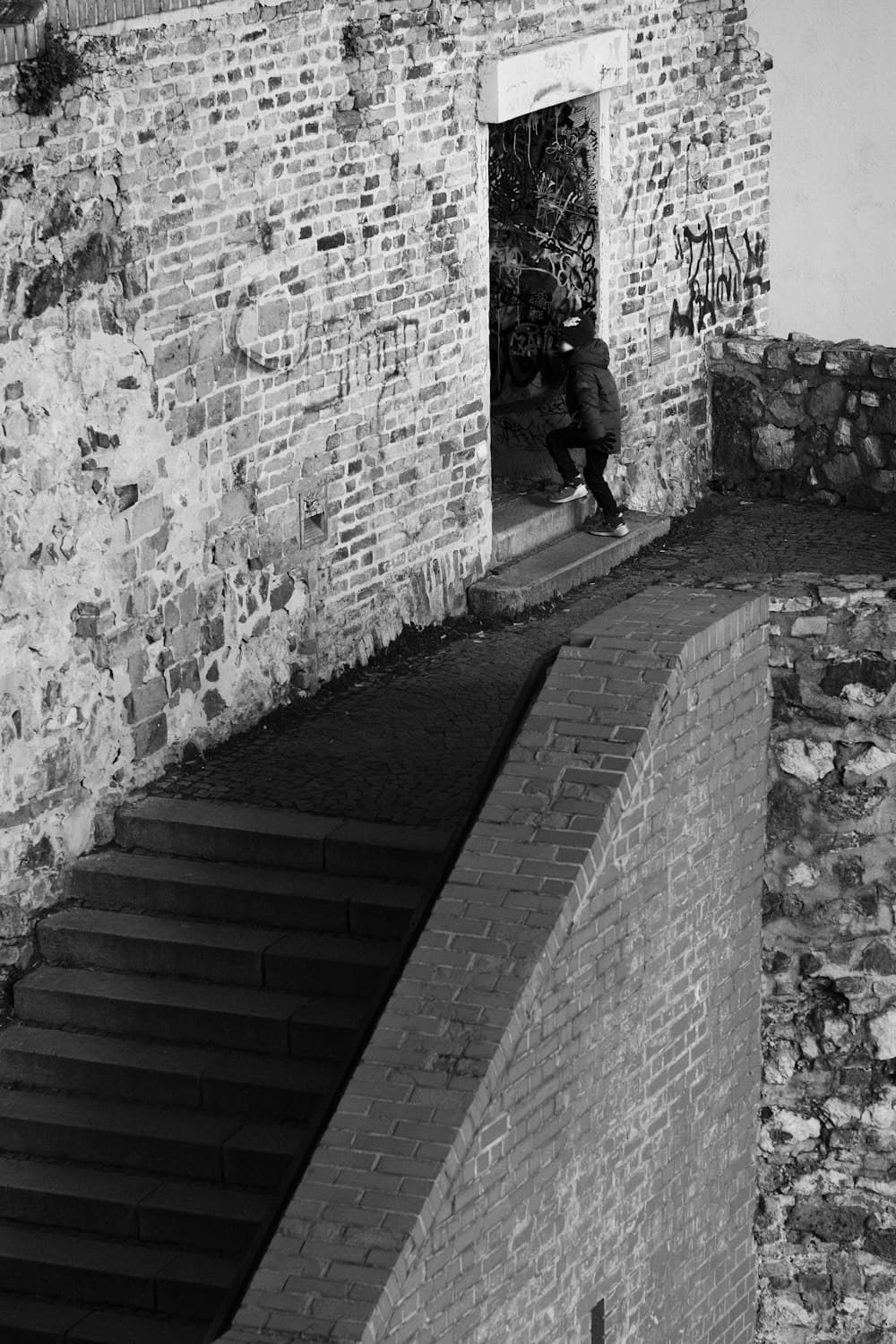 A person walking up a flight of stairs towards an open doorway